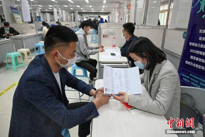 4月14日，招聘者在查看求職者簡歷。<a target='_blank'  data-cke-saved- >中新社</a>記者 王剛 攝