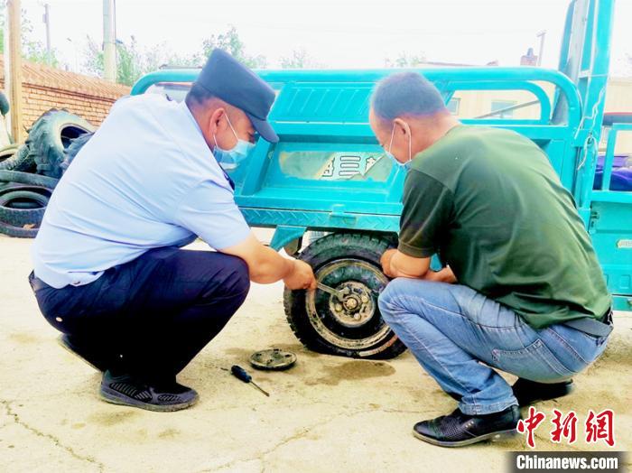 賽旦與民警共同維修三輪摩托車?！∫懒窘?攝