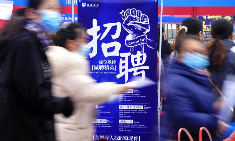 求職者從一家招聘企業(yè)的廣告牌前走過。新華社發(fā)（苑立偉 攝）
