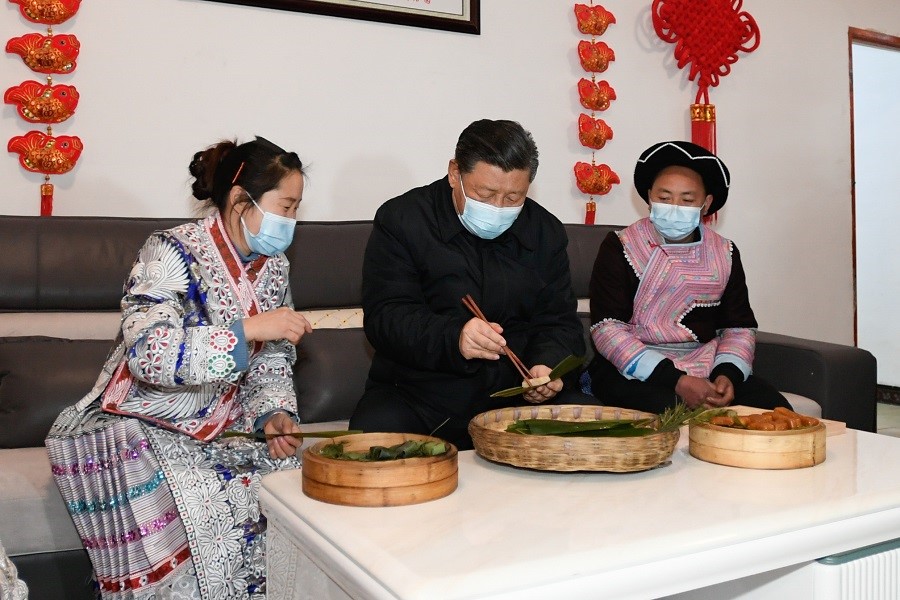 2021年2月3日下午，習(xí)近平在貴州畢節(jié)市黔西縣新仁苗族鄉(xiāng)化屋村苗族村民趙玉學(xué)家，同一家人邊聊家常邊制作當(dāng)?shù)貍鹘y(tǒng)節(jié)日食品黃粑。新華社記者 李學(xué)仁 攝